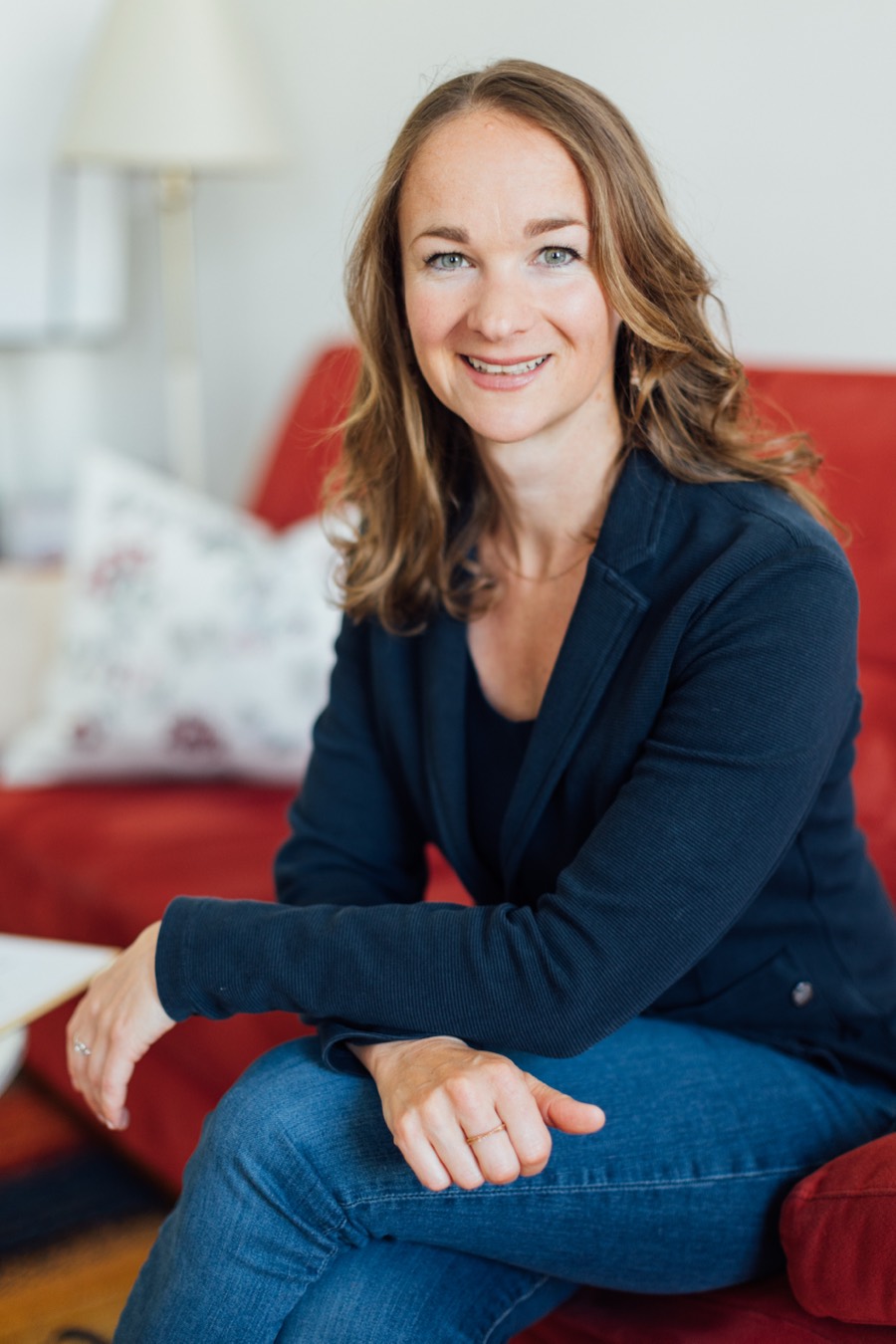 Mag. Katharina Pichler auf dem roten Sofa ihrer Praxis